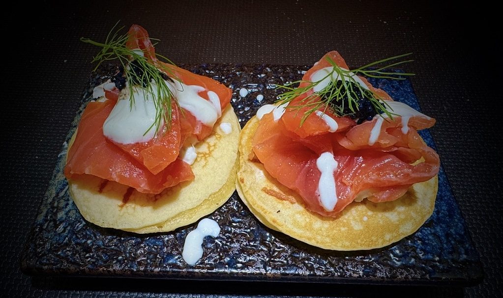 Blinis con salmone marinato, panna acida, caviale e aneto