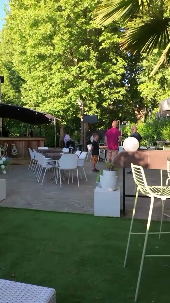 Il prato verde con le palme, il pergolato e i tavoli all'aperto