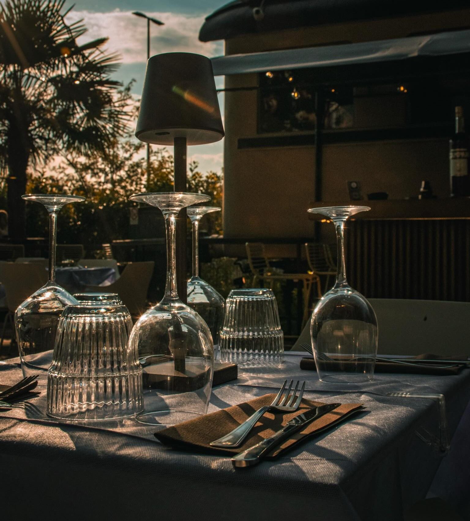Tavolo apparecchiato con i calici, al tramonto